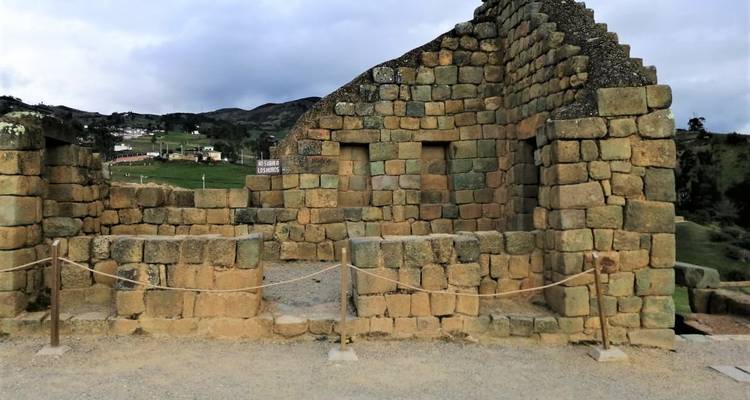 Stone walls and trapezoidal niches of the Inca-Cañari ruins of Ingapirca amid green hills.