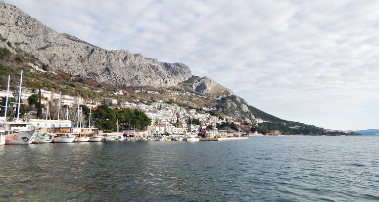 Havenstad Omis met boten en ruige bergen langs de Adriatische kust