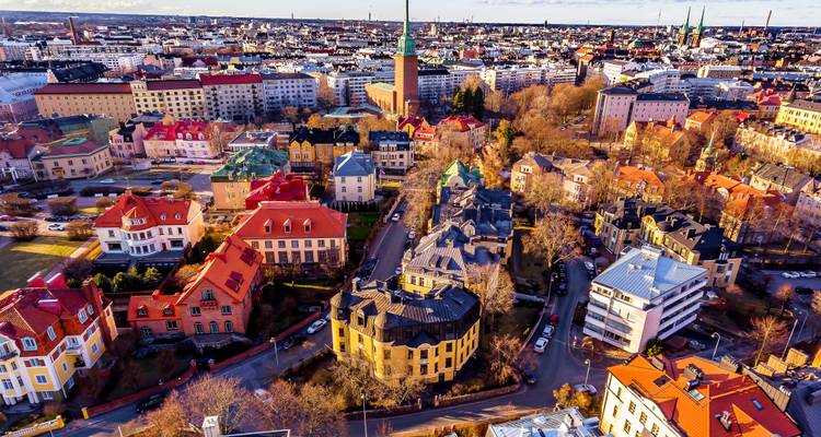 Bird’s-eye view of a northern European cityscape with colorful houses and church spires bathed in late afternoon light.