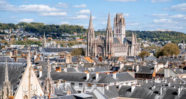Rooftop panorama of Rouen with its towering Gothic cathedral amid rolling green hills