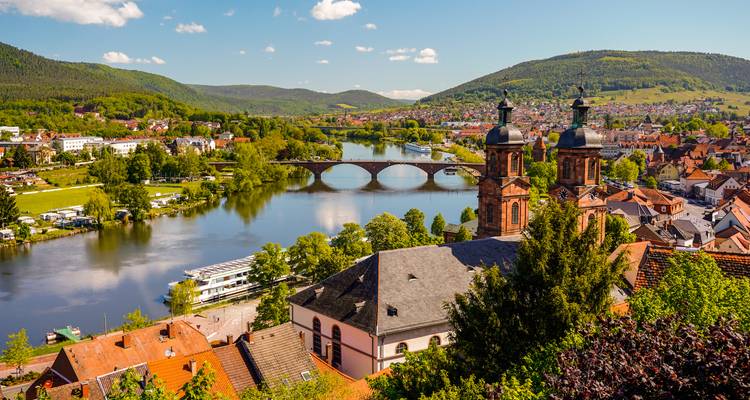 Schilderachtig panorama over Miltenberg met brug over de Main en twee karakteristieke kerktorens.
