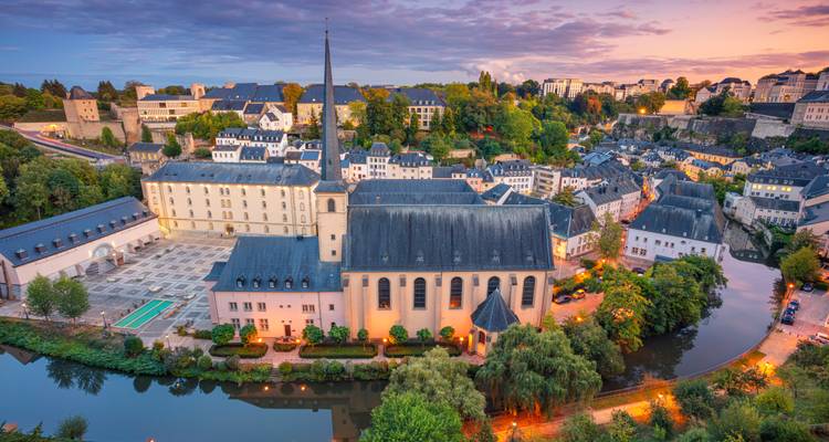 Le quartier du Grund à Luxembourg illuminé au crépuscule avec des reflets dans la rivière Alzette.