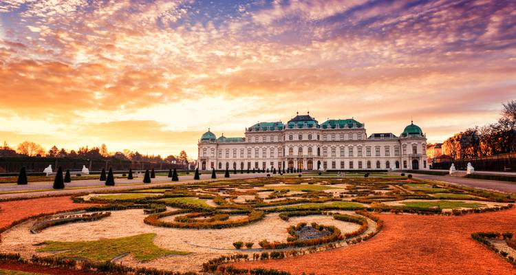 Le Palais du Belvédère et ses jardins à la française se dressent sous un ciel de lever de soleil spectaculaire.