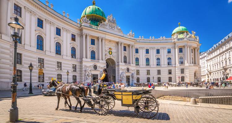 Paard-en-wagen en toeristen voor de grandioze barokke ingang van het Michaelerplatz van het Hofburg Palace in Wenen.