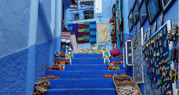 Escalier bleu escarpé bordé d'objets artisanaux colorés et de couvertures en vente