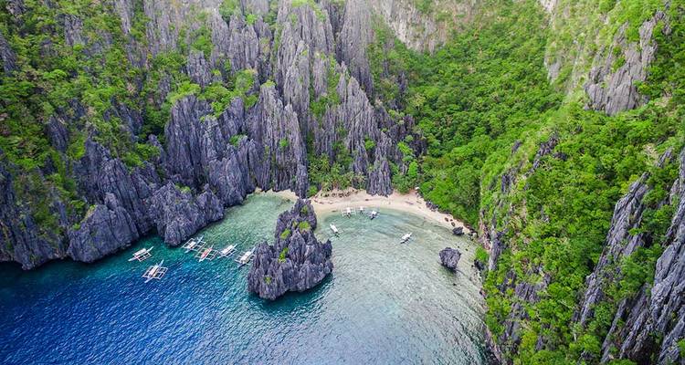 Vue aérienne des falaises calcaires déchiquetées, du lagon caché et des eaux bleues à Palawan.