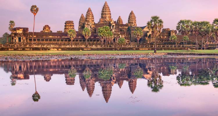 Le reflet iconique du lever de soleil des tours d'Angkor Wat se reflétant parfaitement dans un étang de lotus immobile.