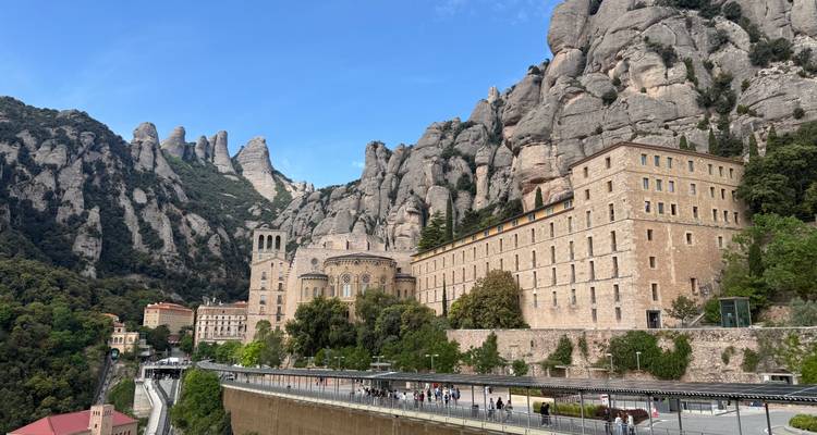 Le monastère de Montserrat niché sous les pics de calcaire dentelés dramatiques lors d'une journée ensoleillée.