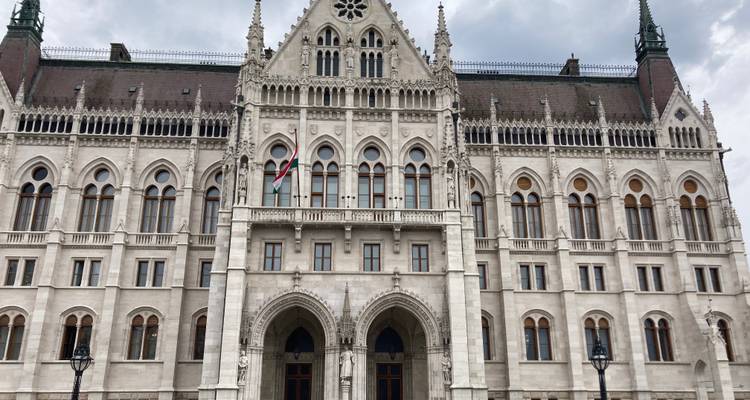 Voorkant van het Hongaarse Parlement met symmetrische neogotische details onder grijze lucht