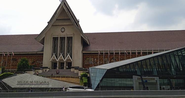 Bâtiment du Musée national avec toit traditionnel et extension en verre moderne le long d'une rue animée à Kuala Lumpur