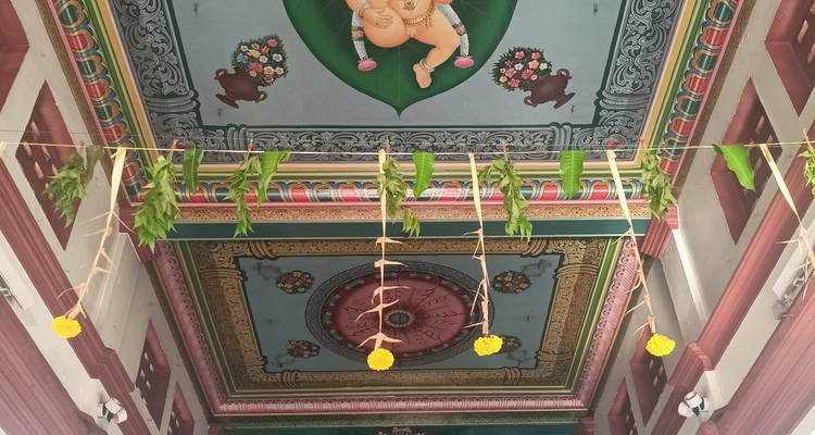 Dekorative Hindu-Tempeldecke mit einem zentralen Lotusdesign und einer Ganesha-Figur mit hängenden Blumenopfergaben
