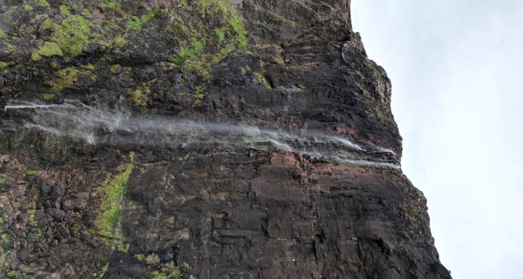 Haute cascade côtière se précipitant sur des falaises de basalte sombre