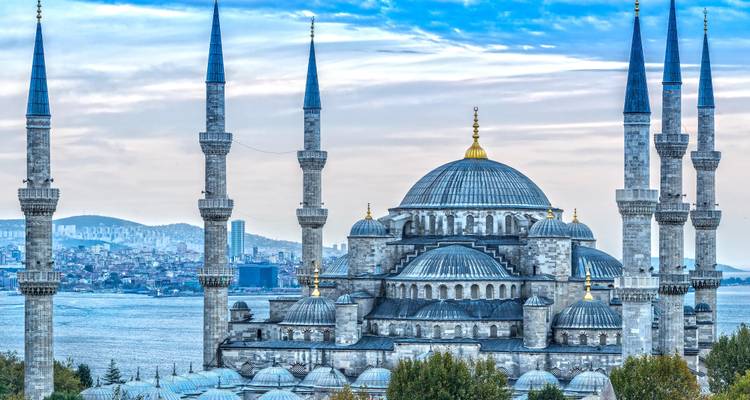 Vue détaillée en téléobjectif des dômes et des minarets de la Mosquée Bleue se dressant sur fond du Bosphore et de la skyline urbaine.