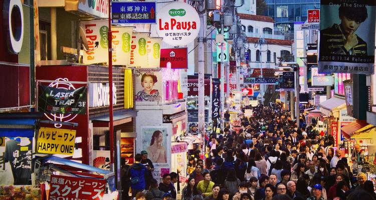 Drukke Takeshita Street vol met winkelende mensen en kleurrijke borden in Tokio's Harajuku-wijk.
