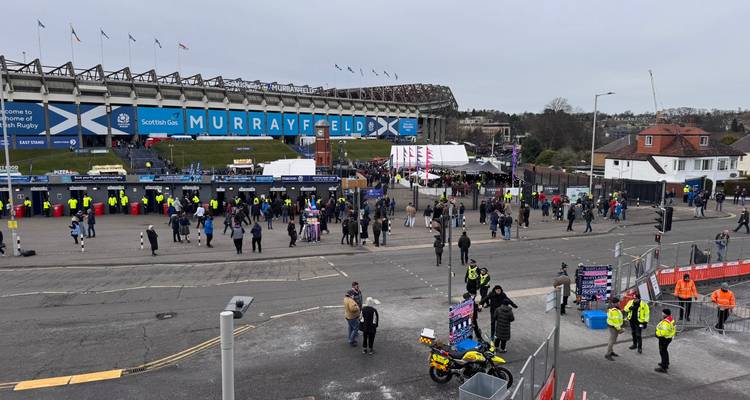 Des foules se rassemblant à l'extérieur du stade de Murrayfield pour un match de rugby avec le personnel de l'événement et des drapeaux flottant