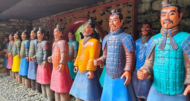 Een kleurige rij replica Terracotta Krijger-standbeelden tentoongesteld in een oosterse tuinzaal.
