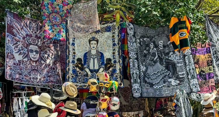 Straatmartkraam vol levendige textiel, maskers, hoeden en kunstwerken