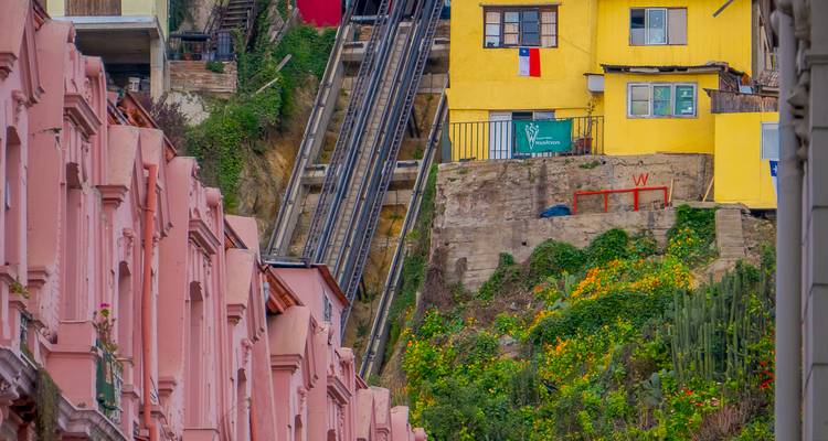 Les bâtiments aux couleurs rose vif et jaune qui bordent les pentes sont encadrés par un funiculaire escarpé à Valparaiso.