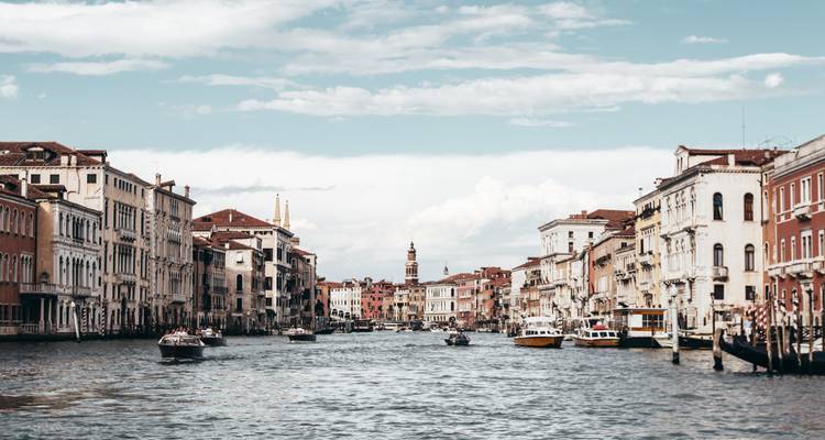 Le Grand Canal à Venise bordé de palais historiques avec des bateaux qui naviguent par une journée ensoleillée.