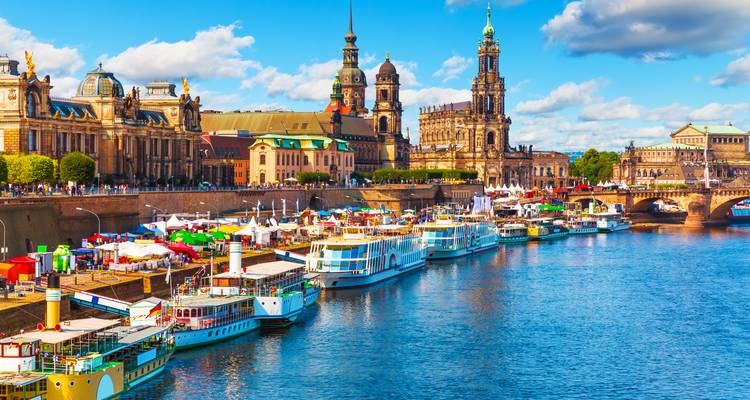 Les étals colorés du marché riverain et les tours historiques se reflétant dans l'Elbe lors d'une journée lumineuse à Dresde