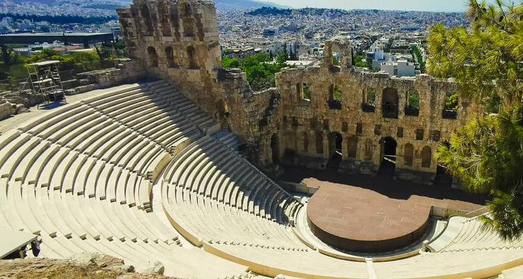 Les gradins semi-circulaires en pierre de l'ancien Odéon d'Hérode Atticus dominant Athènes moderne.
