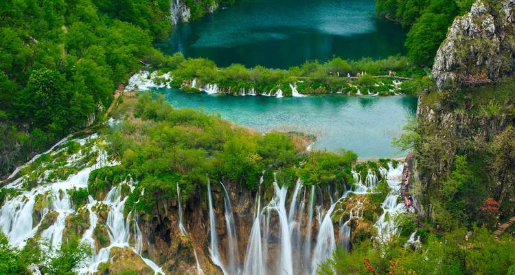 Terraced turquoise lakes and cascading waterfalls surrounded by dense green forest at Plitvice.
