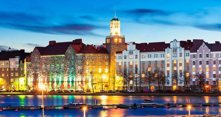 Avondelijk stadsgezicht van waterkantgebouwen die gloeien met kleurrijke verlichting