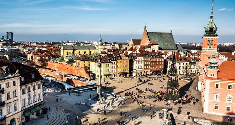 Expansive view over Warsaw's Old Town square with colorful buildings and crowds
