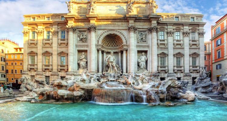 Der Trevi-Brunnen mit seiner skulptierten Fassade und dem türkisfarbenen Becken, das vom Morgenlicht beleuchtet wird.