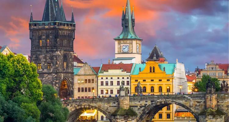 Charles Bridge en Old Town torens bij een levendige zonsondergang met menigtes die oversteken