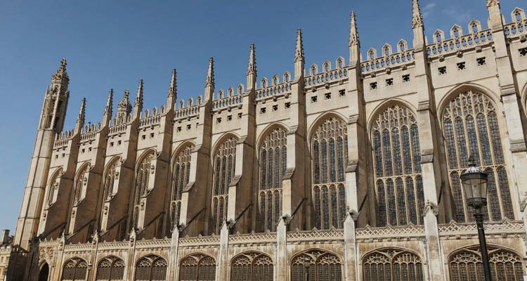 Gotische Spitztueren und hohe Buntglasfenster der King's College Chapel in Cambridge vor einem klaren Himmel