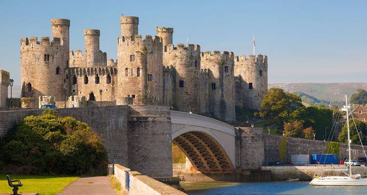 Mittelalterliche Conwy Castle mit massiven Rundtürmen, die eine Steinbrücke und einen ruhigen Fluss überragen