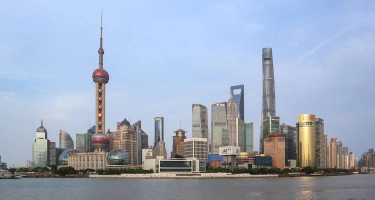 Modern skyline of Shanghai with the Oriental Pearl Tower and towering skyscrapers viewed across the Huangpu River.