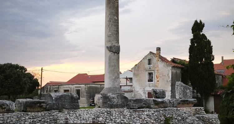Colonne de pierre ancienne et ruines au coucher du soleil dans un village croate