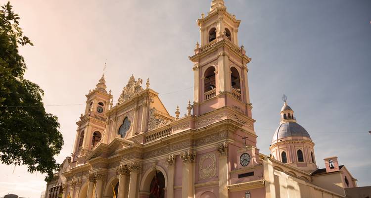 La Cathédrale de Salta, d'un rose délicat, s'élève dans un ciel dégagé, sa façade ornée étant mise en valeur par le soleil de l'après-midi.