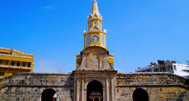 Yellow Clock Tower of Cartagena standing above historic stone walls against blue sky