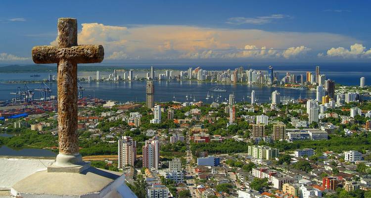 Stone cross overlooking Cartagena skyline and harbor under dramatic clouds
