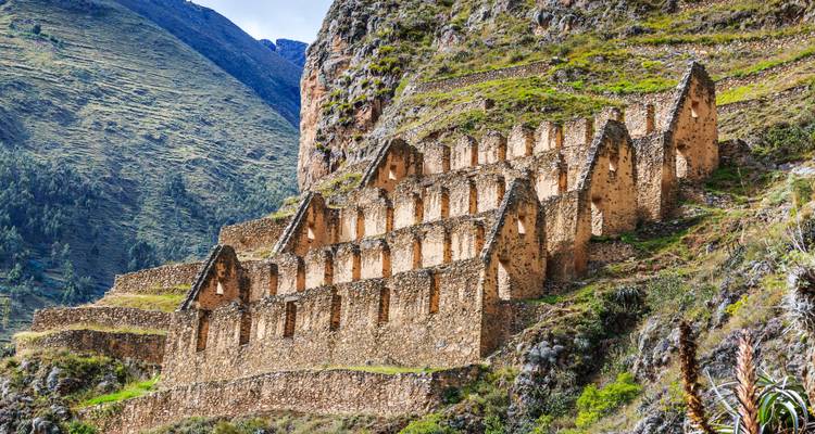 Terraced Inca storehouses cling to a steep green mountainside above the Sacred Valley.
