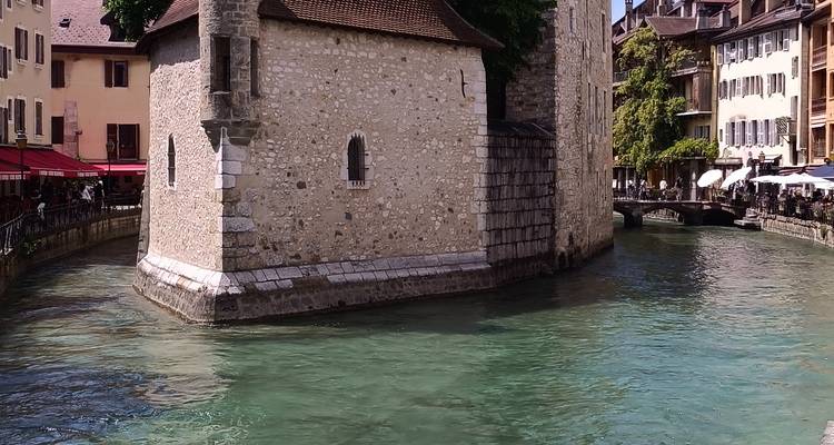 Emblématique Palais de l'Isle en pierre s'élevant des eaux turquoise du canal entre les bâtiments de la vieille ville
