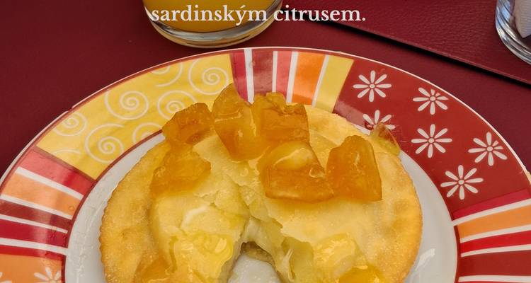 Close-up of citrus tart on colorful plate with overlaid descriptive text.