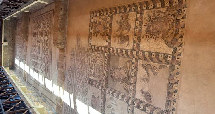 Hall displaying preserved Roman mosaics illuminated by skylight