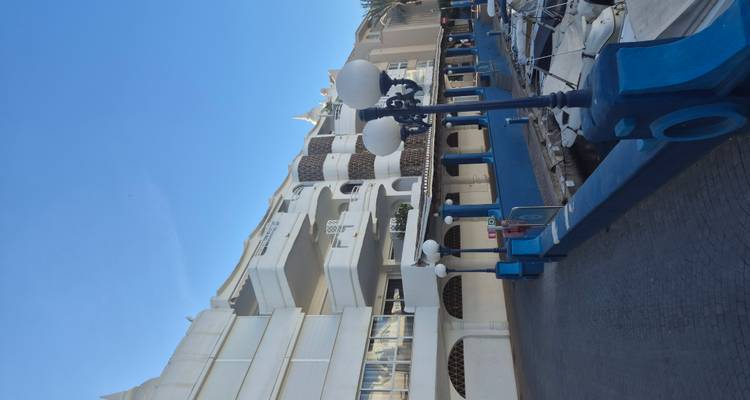 Blue and white waterfront promenade with modern apartments and marina