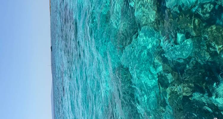 Vaste étendue d'eau méditerranéenne turquoise sous un ciel dégagé.