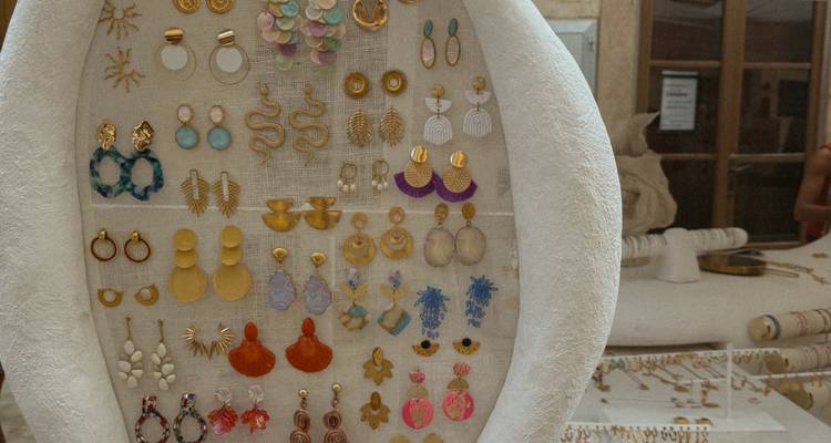 Panneau d'affichage rempli de boucles d'oreilles artisanales colorées dans un marché d'artisans.