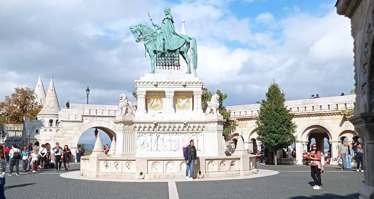 Statue of King Stephen I on horseback in the central courtyard of Fisherman’s Bastion surrounded by tourists.