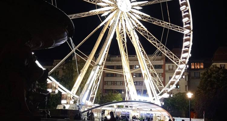 Large illuminated ferris wheel spinning at night in Budapest’s city center.