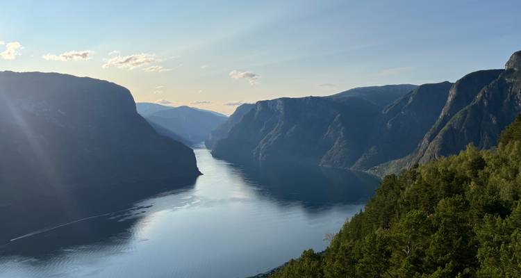 Vue spectaculaire sur le Aurlandsfjord avec des falaises baignées de soleil et une eau calme et réfléchissante à l'heure dorée.