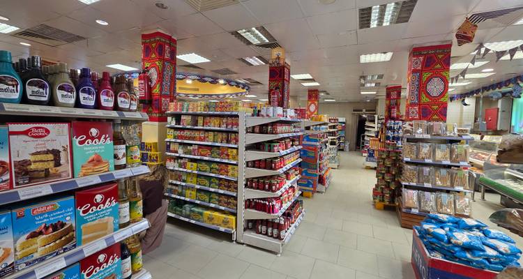 Interior aisle of a grocery store with neatly organized shelves of packaged foods and spices.