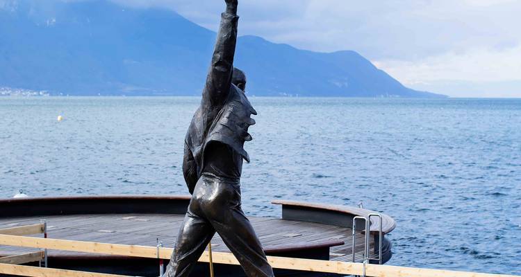 Bronze Freddie Mercury statue on Montreux’s waterfront with Lake Geneva and mountains behind.