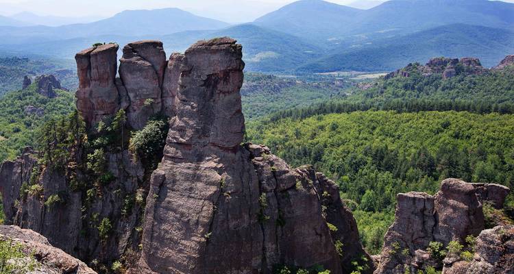Des pics de grès dramatiques s'élèvent au-dessus d'une vaste vallée boisée à Belogradchik.